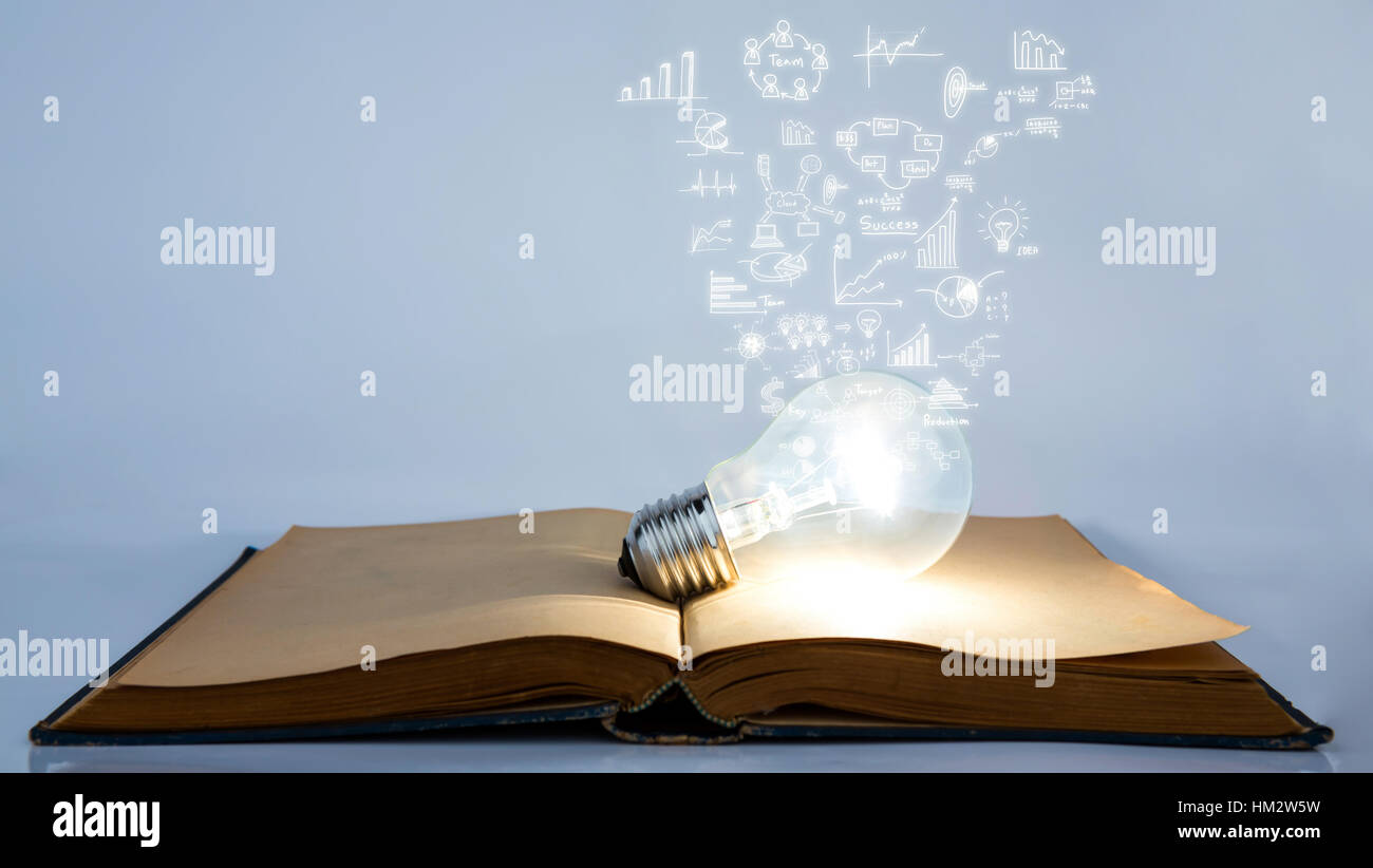 Book and light bulb with business graph Stock Photo - Alamy