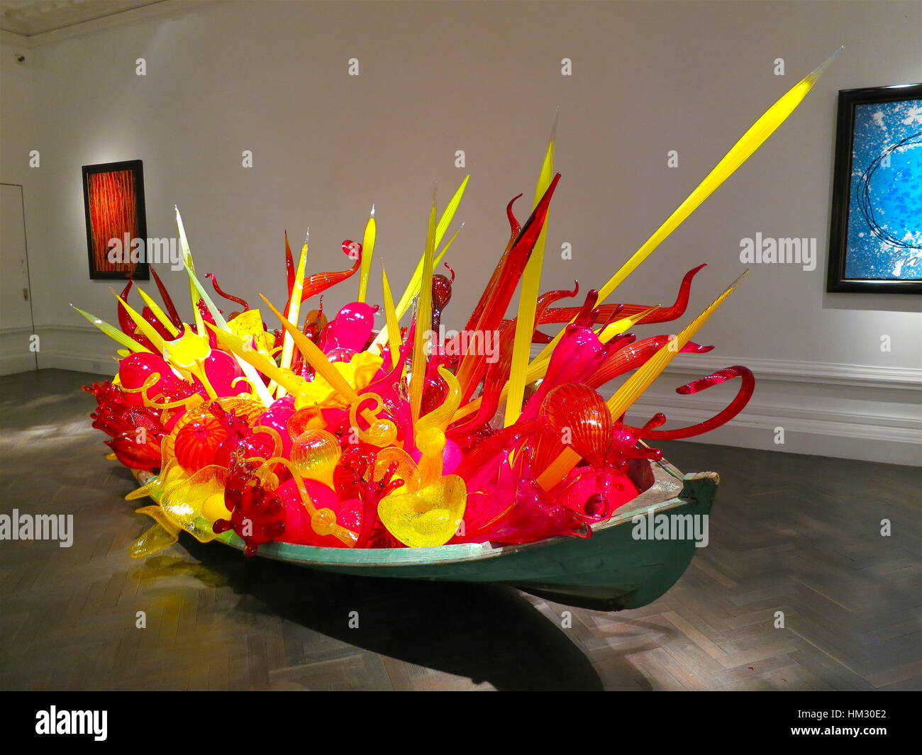 Red pink and yellow glass sculpture in a boat created by American artist Dale Chihuly. Halcyon Gallery, London. April 2014 Stock Photo