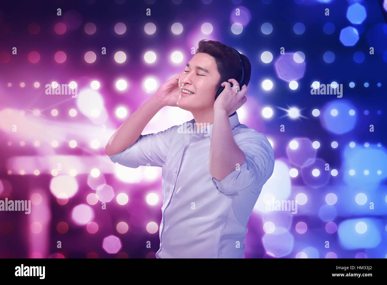 Young asian man listening music headphones with relax over blurred light background Stock Photo