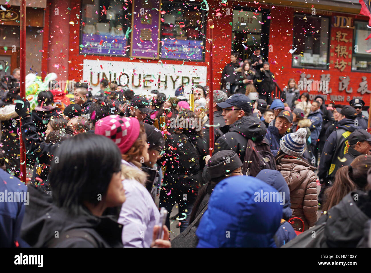 Confetti and glitter from giant party poppers falls on a crowd of