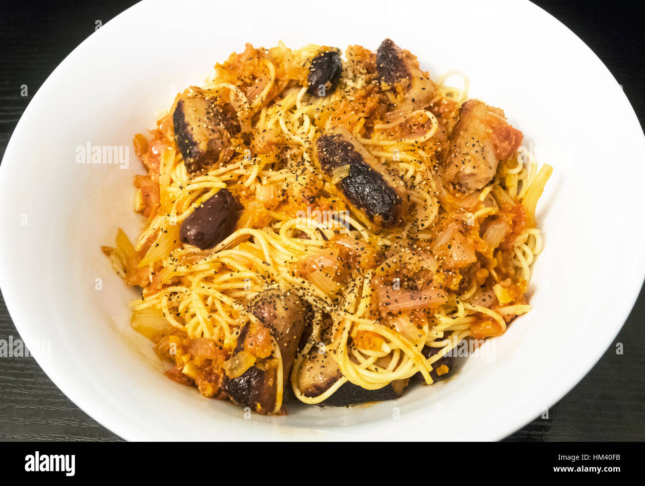 Thin spaghetti with onions, sausage, and tomato sauce Stock Photo Alamy