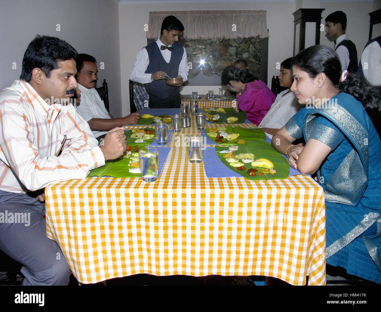 People having south Indian Thali (special meals prepared for Onam festival). Traditionally served on banana leaf. Kerala, India Stock Photo