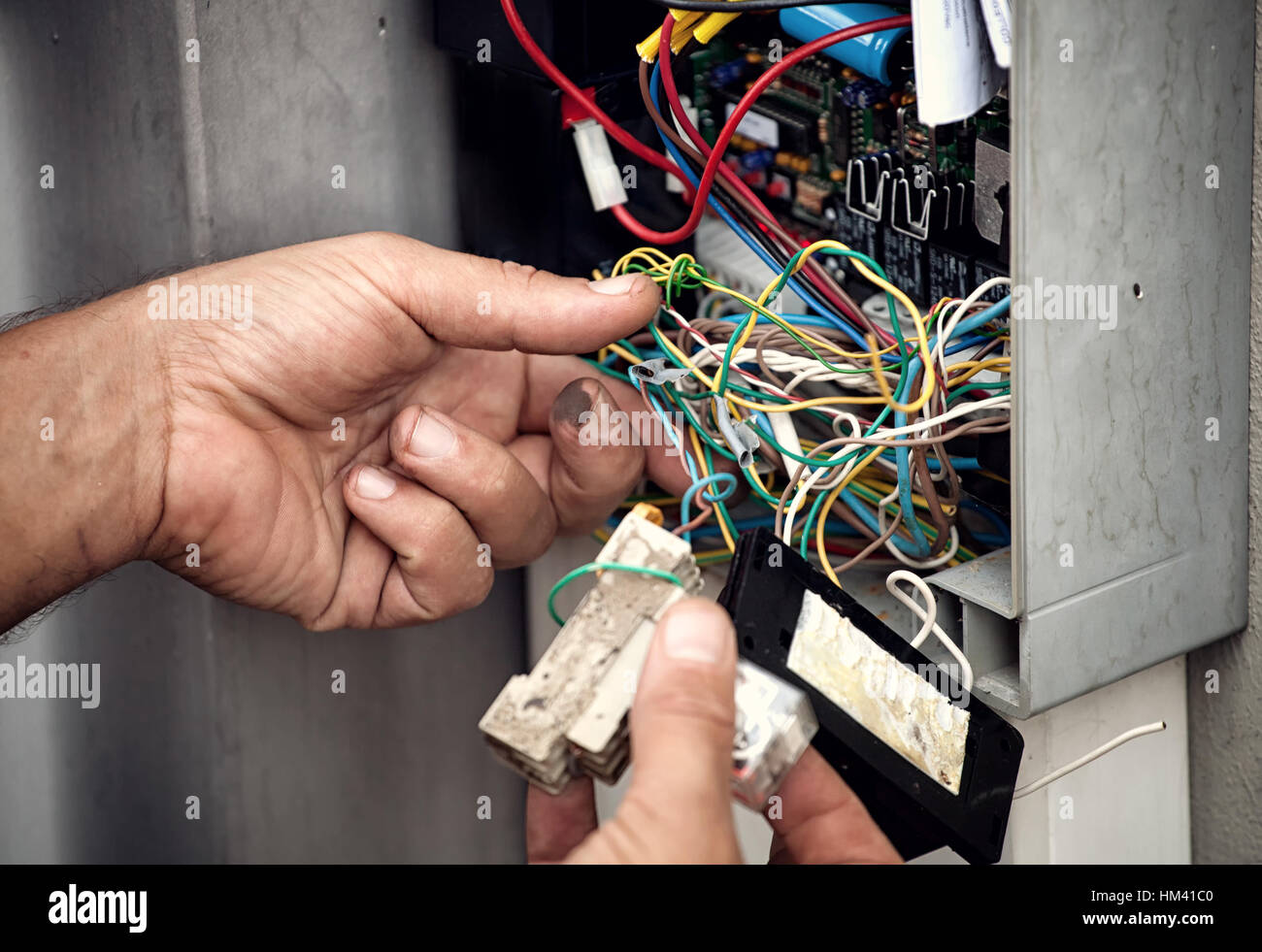 Electrician repairing electric system of an automatic gate. Stock Photo