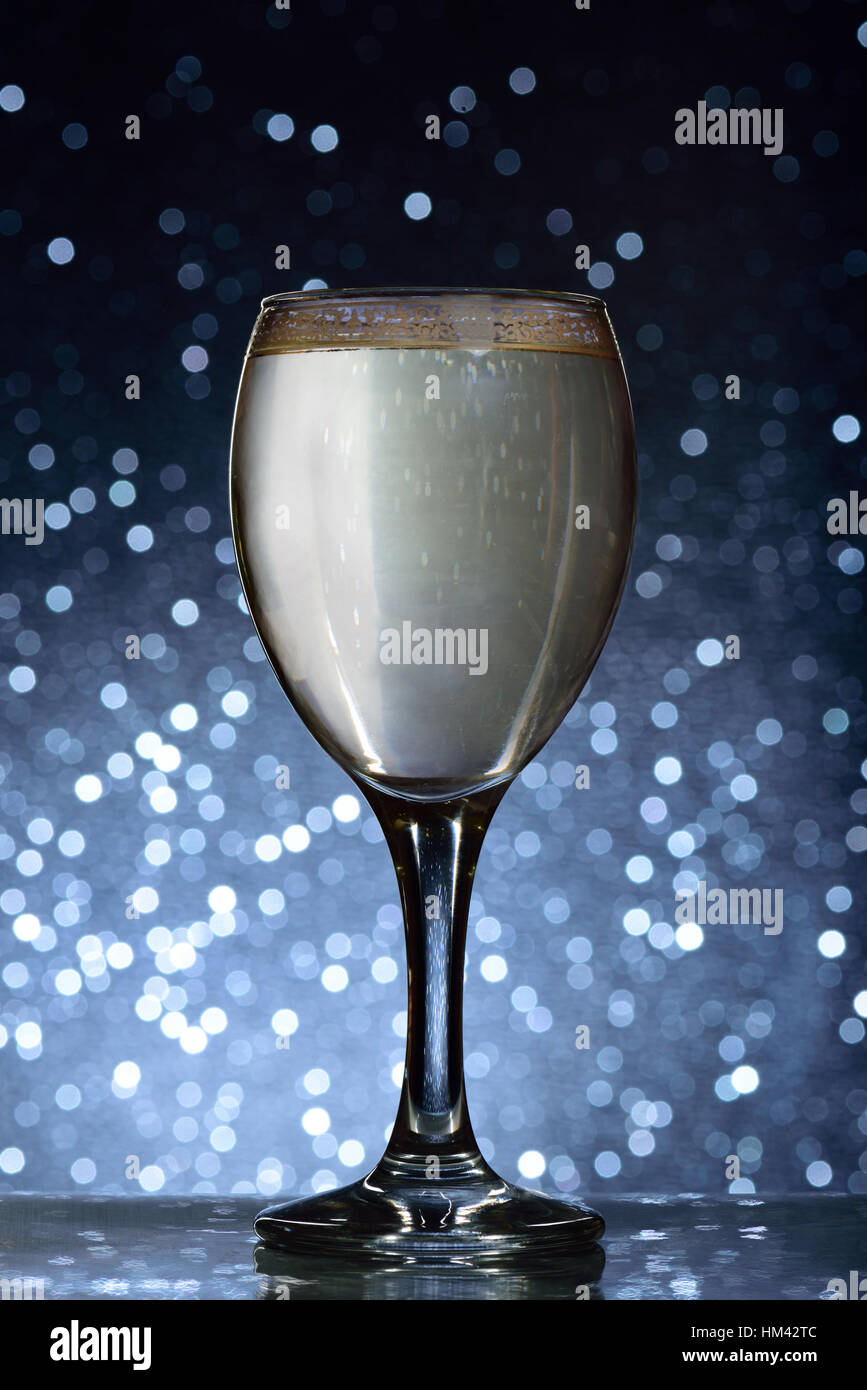 Glass with white wine on blue blurred background Stock Photo