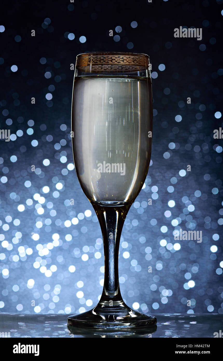 Glass with champagne on blue bokeh background Stock Photo
