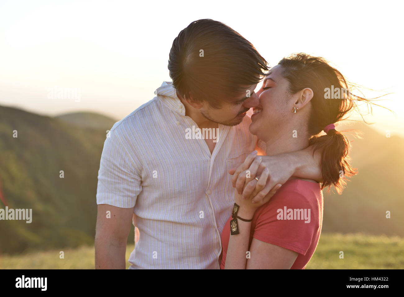 kissing man and woman in gold sunset light Stock Photo