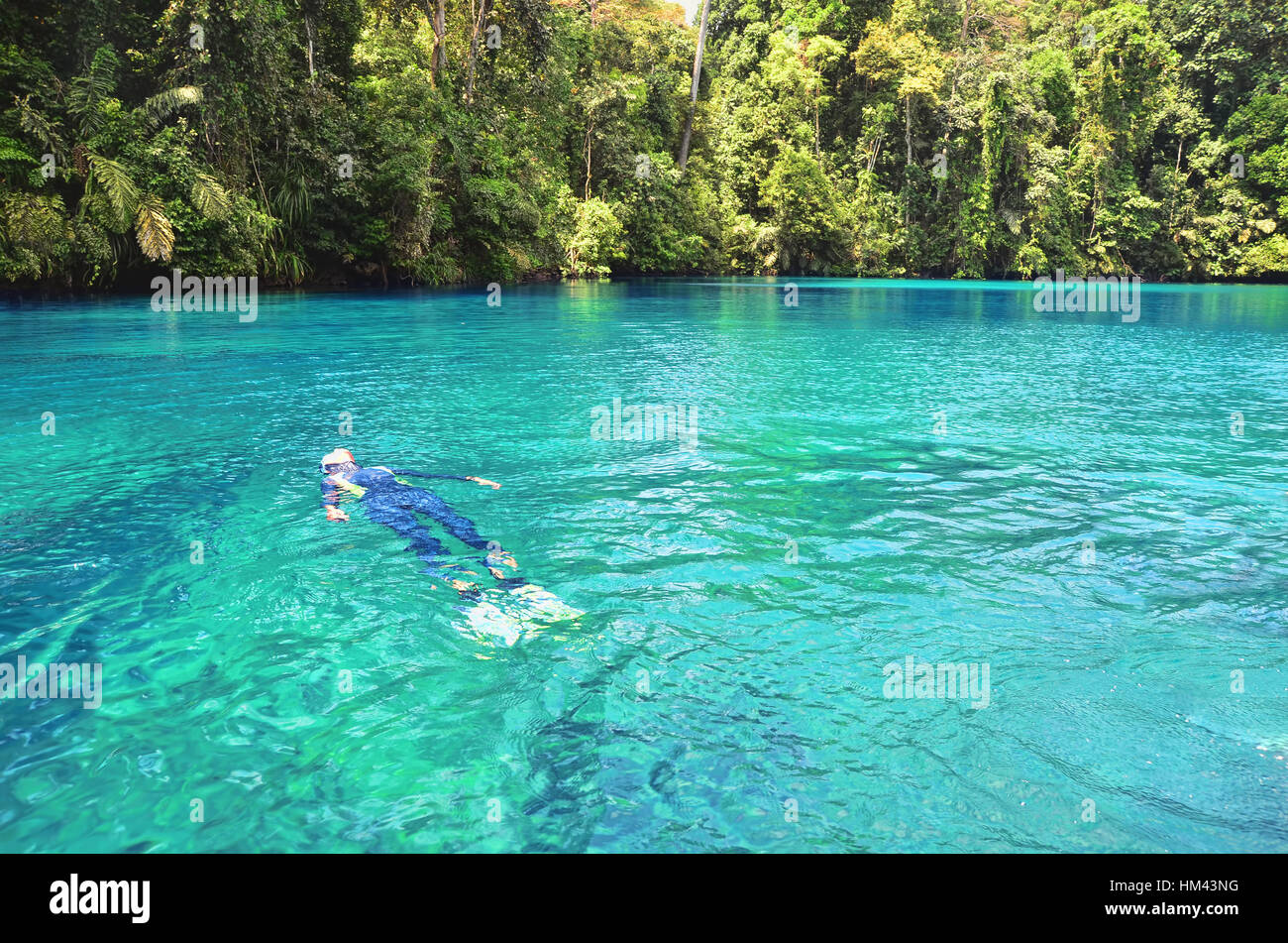 Swimmer floating on the surface of Labuan Cermin Lake Stock Photo