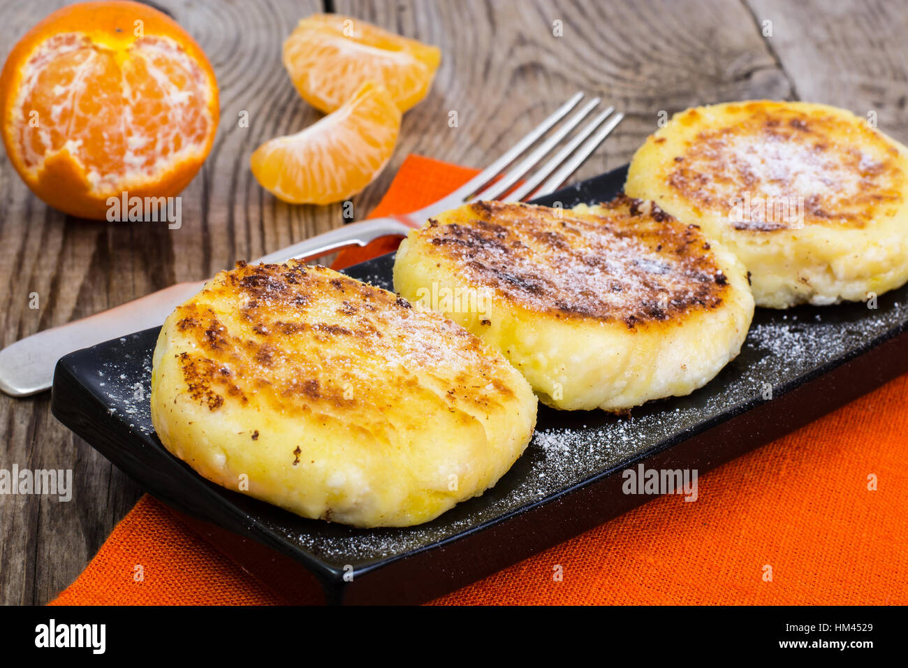 Hot sweet cheesecakes with tangerines and honey Stock Photo