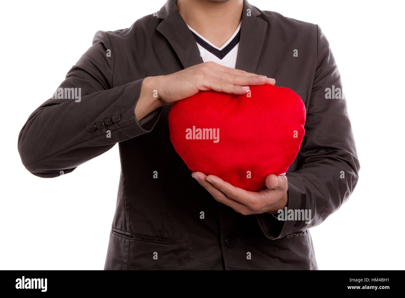 Man holding heart shape pillow over white background Stock Photo - Alamy