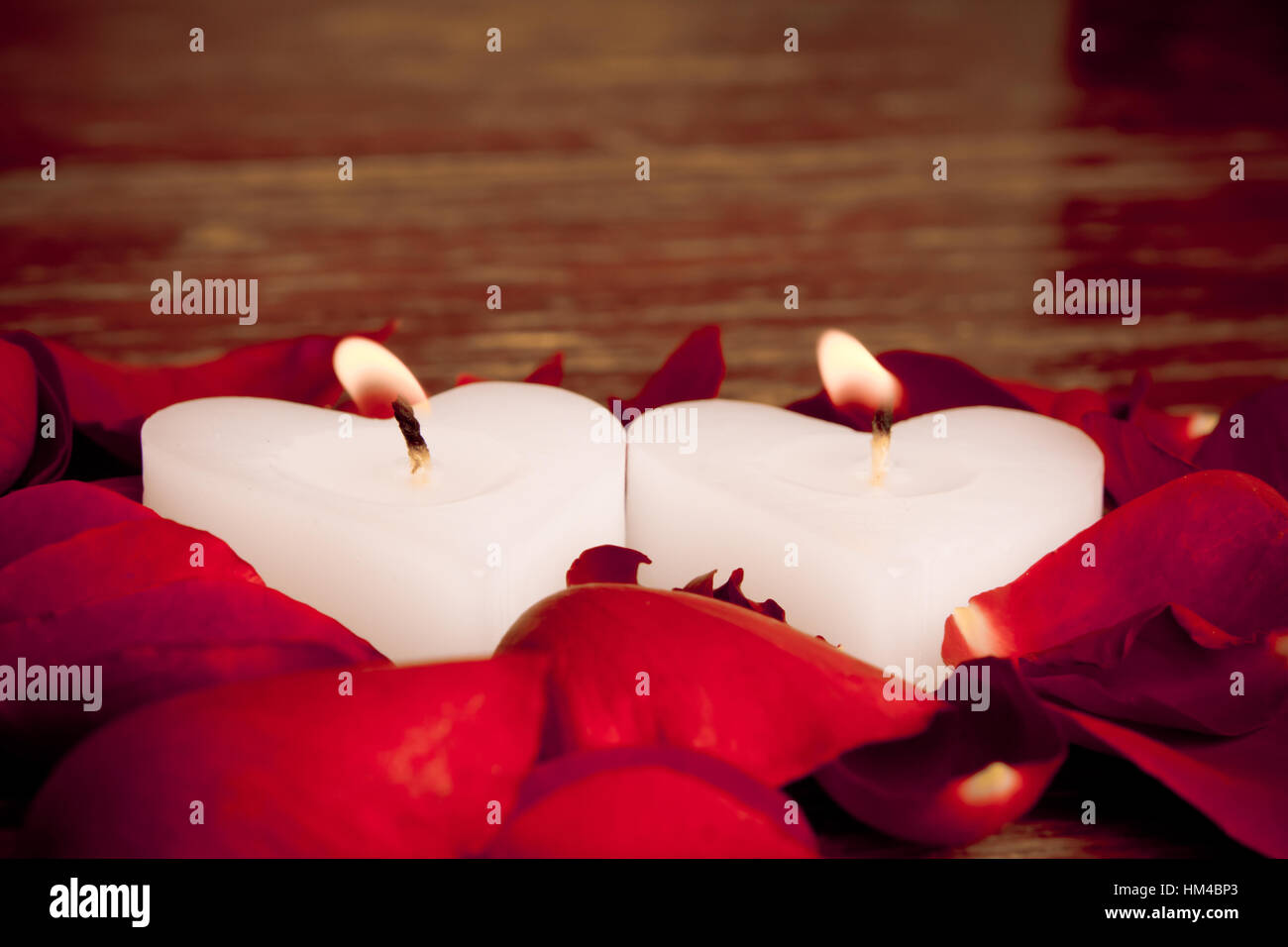 Valentines candles on rose petals background Stock Photo - Alamy