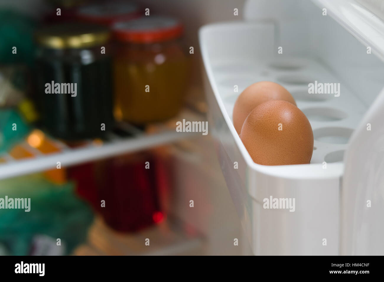 Two chicken eggs on a shelf of the refrigerator door closeup. Inside