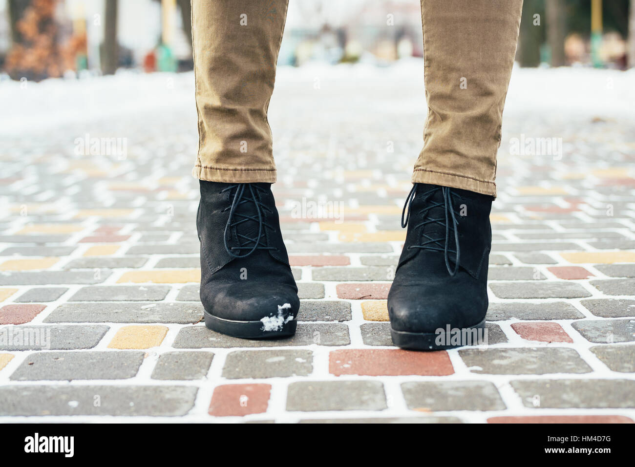 Female feet in brown jeans and black winter boots standing on a snowy  sidewalk closeup Stock Photo - Alamy
