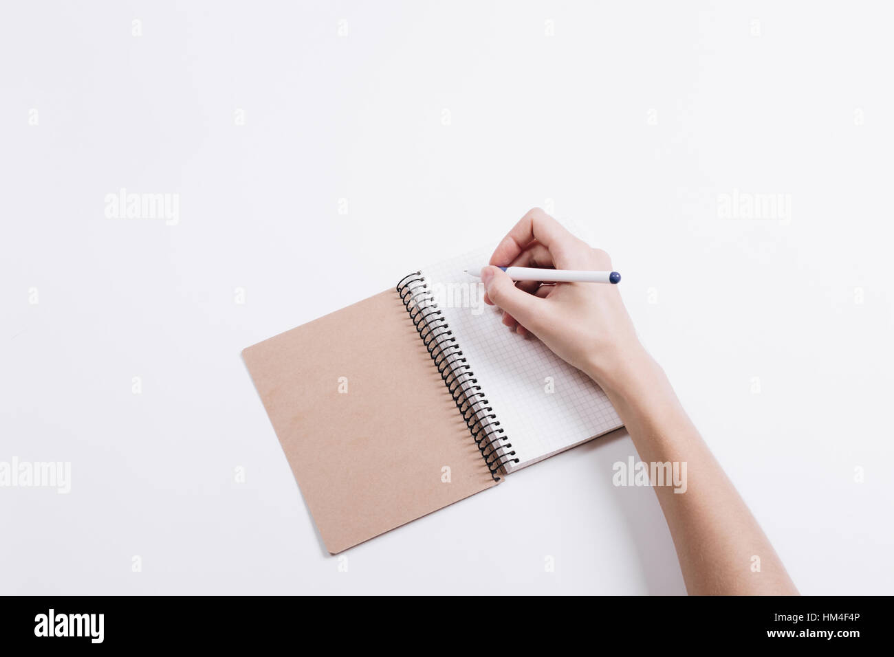 Пишу на белой стене. Блокнот с ручкой. Человек с блокнотом. Блокнот в руке. Рука ручка блокнот