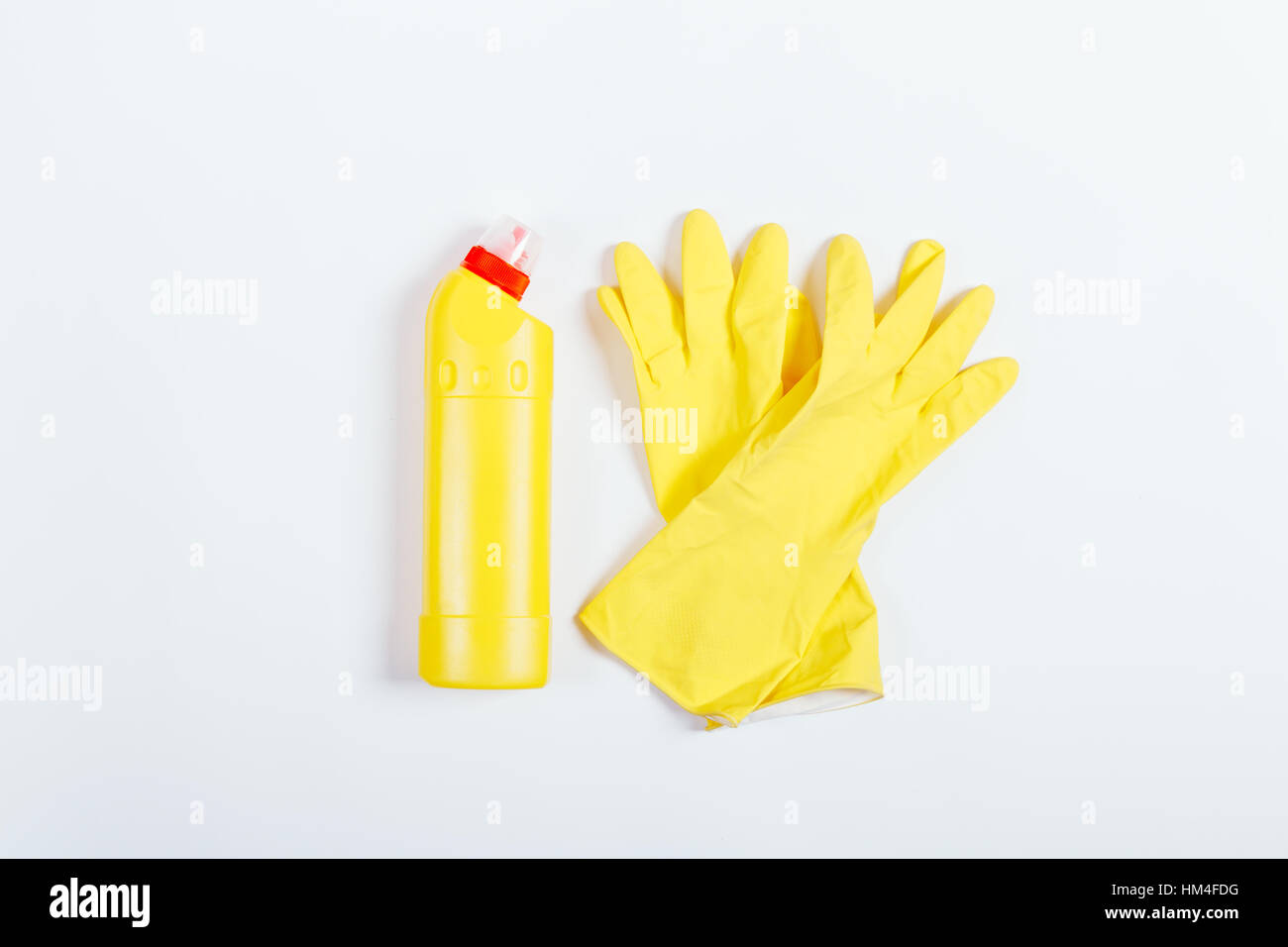 Yellow rubber gloves and a bottle of detergent on white background, top ...