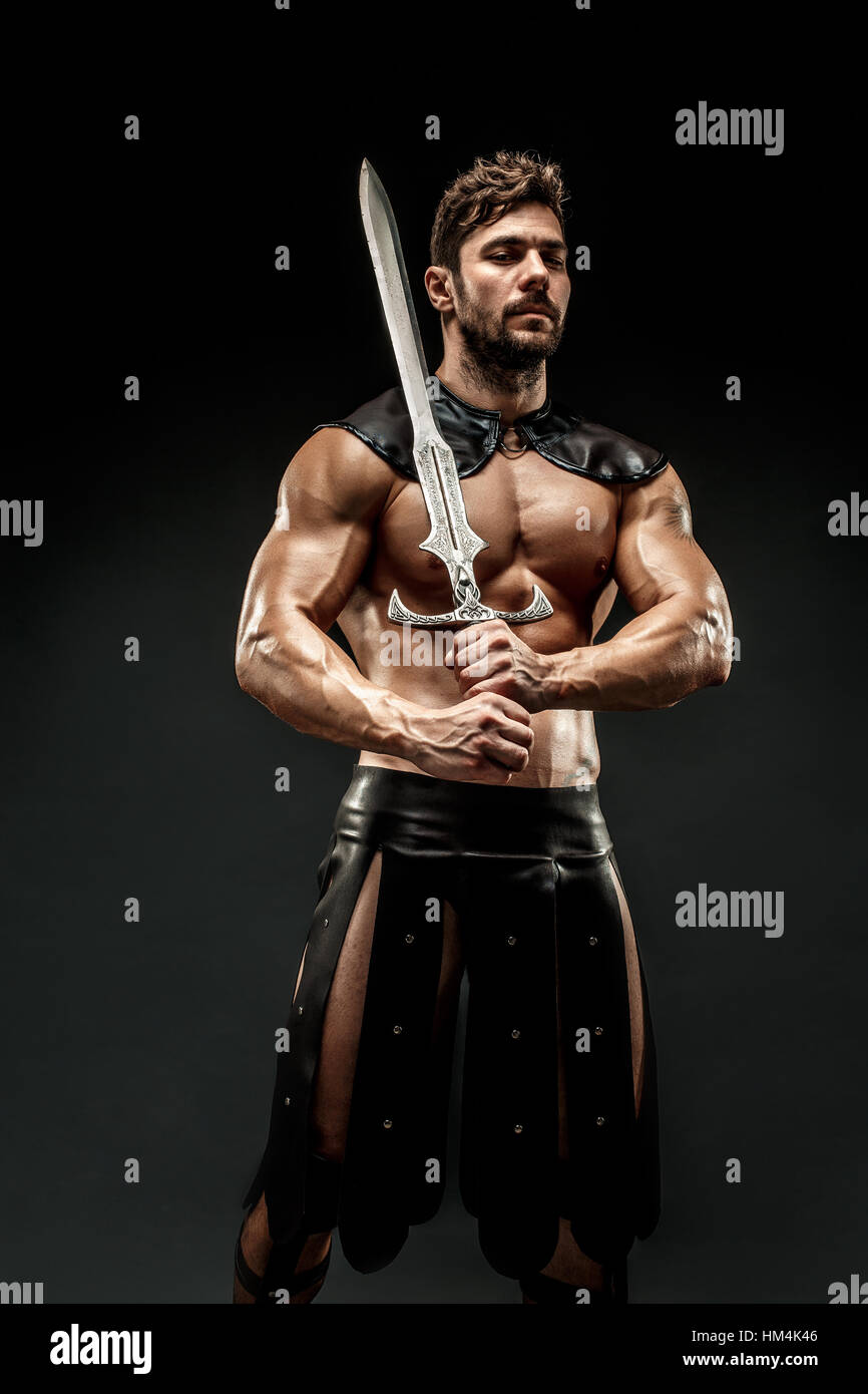 Severe barbarian in leather costume with sword Stock Photo