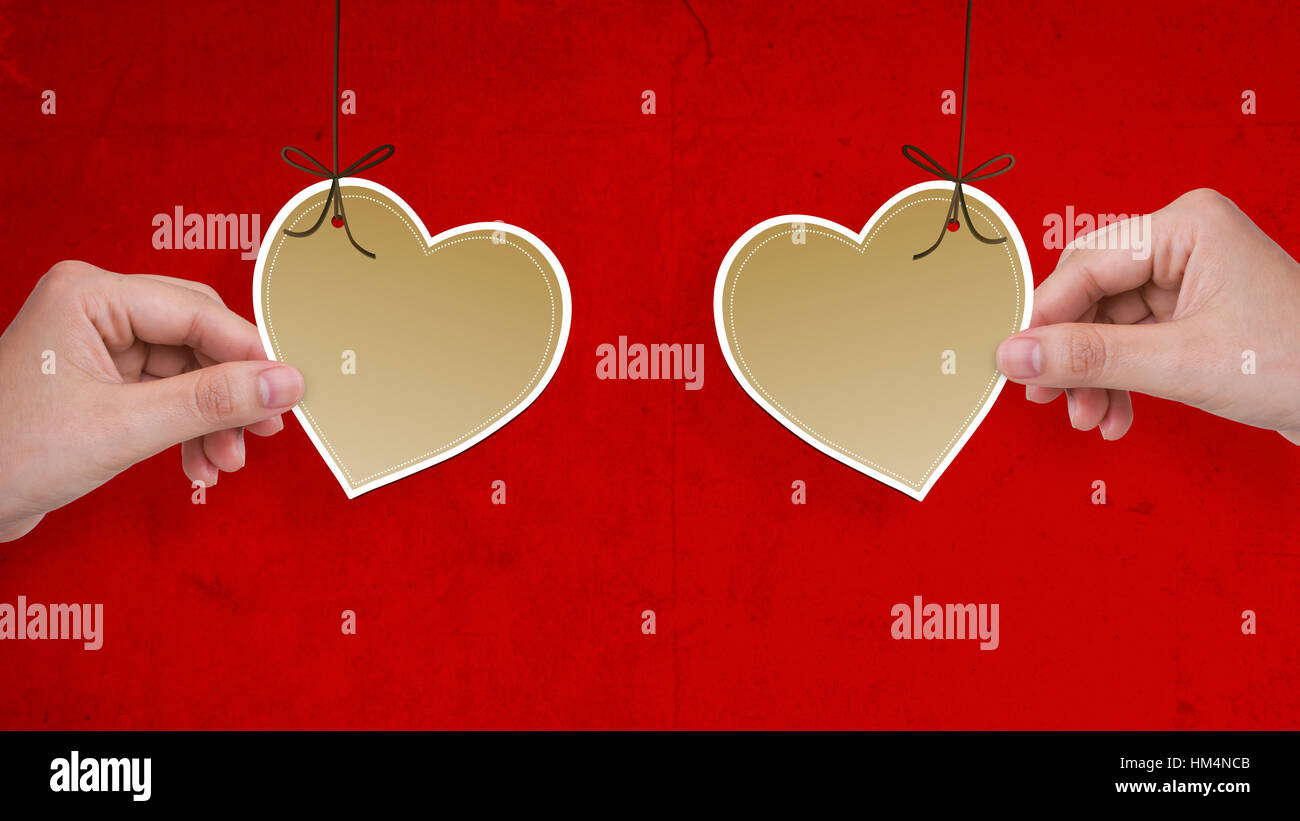 Two hands hold heart paper on red background Stock Photo - Alamy
