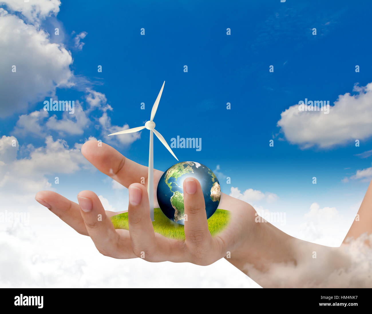 Wind turbines and earth on hand over blue sky (Elements of this image ...