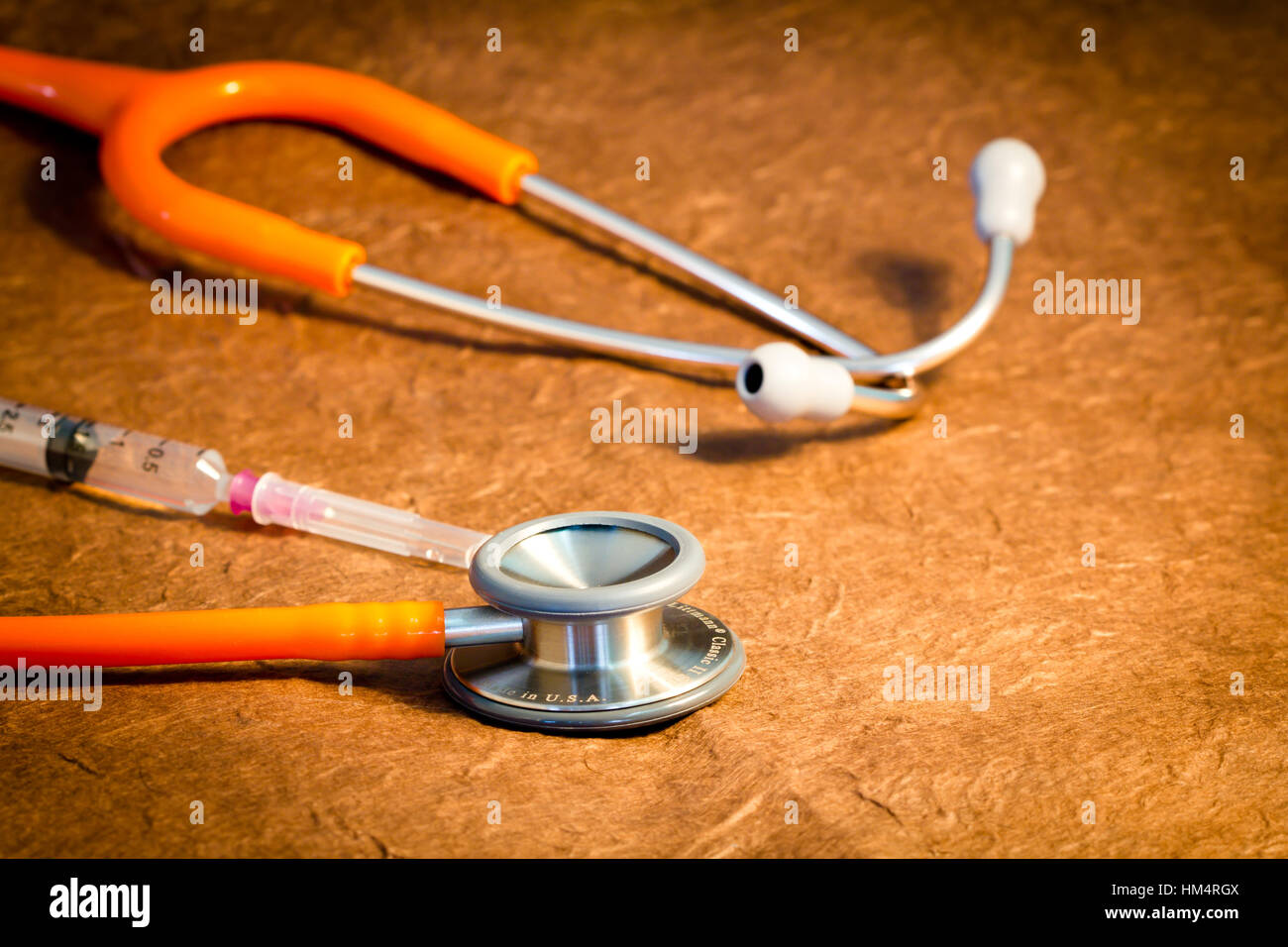 Medical stethoscope and syringe over brown background Stock Photo - Alamy
