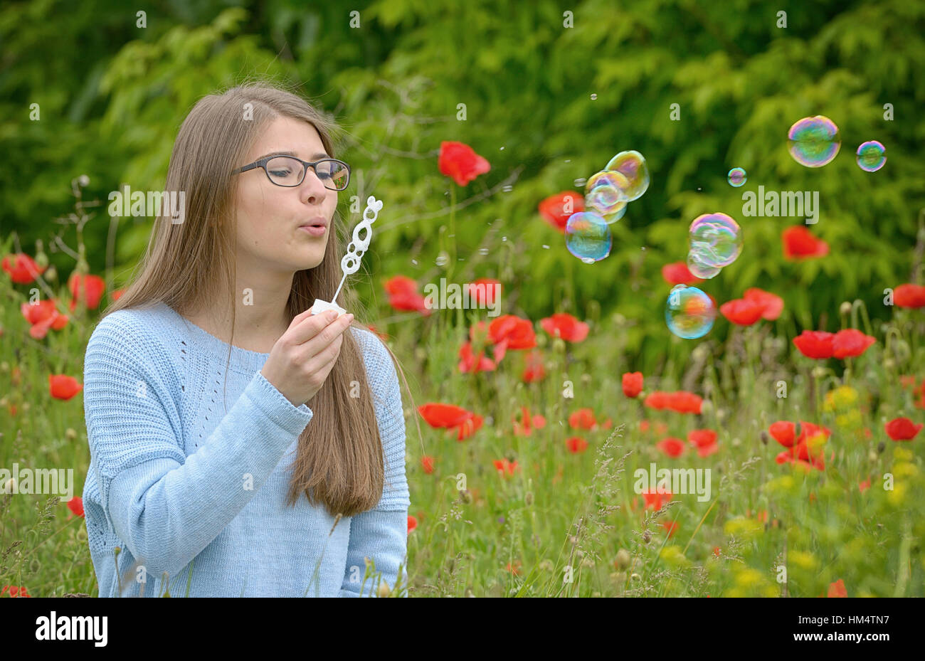 portrait of young girl with soap bubbles in forest Stock Photo