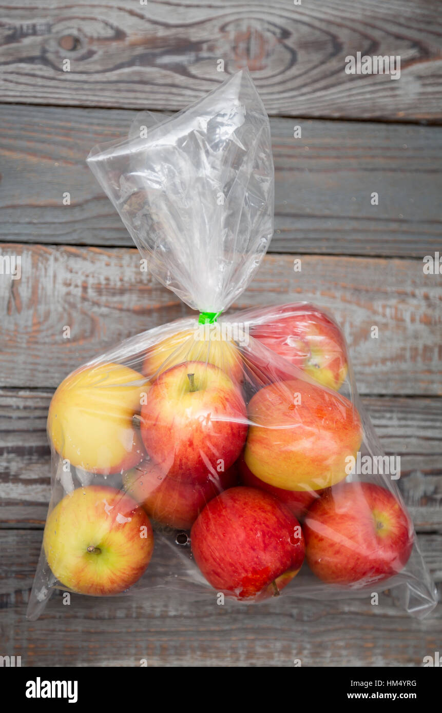 Apple fruit in plastic bag on wood table Stock Photo by ©jannystockphoto  77413662