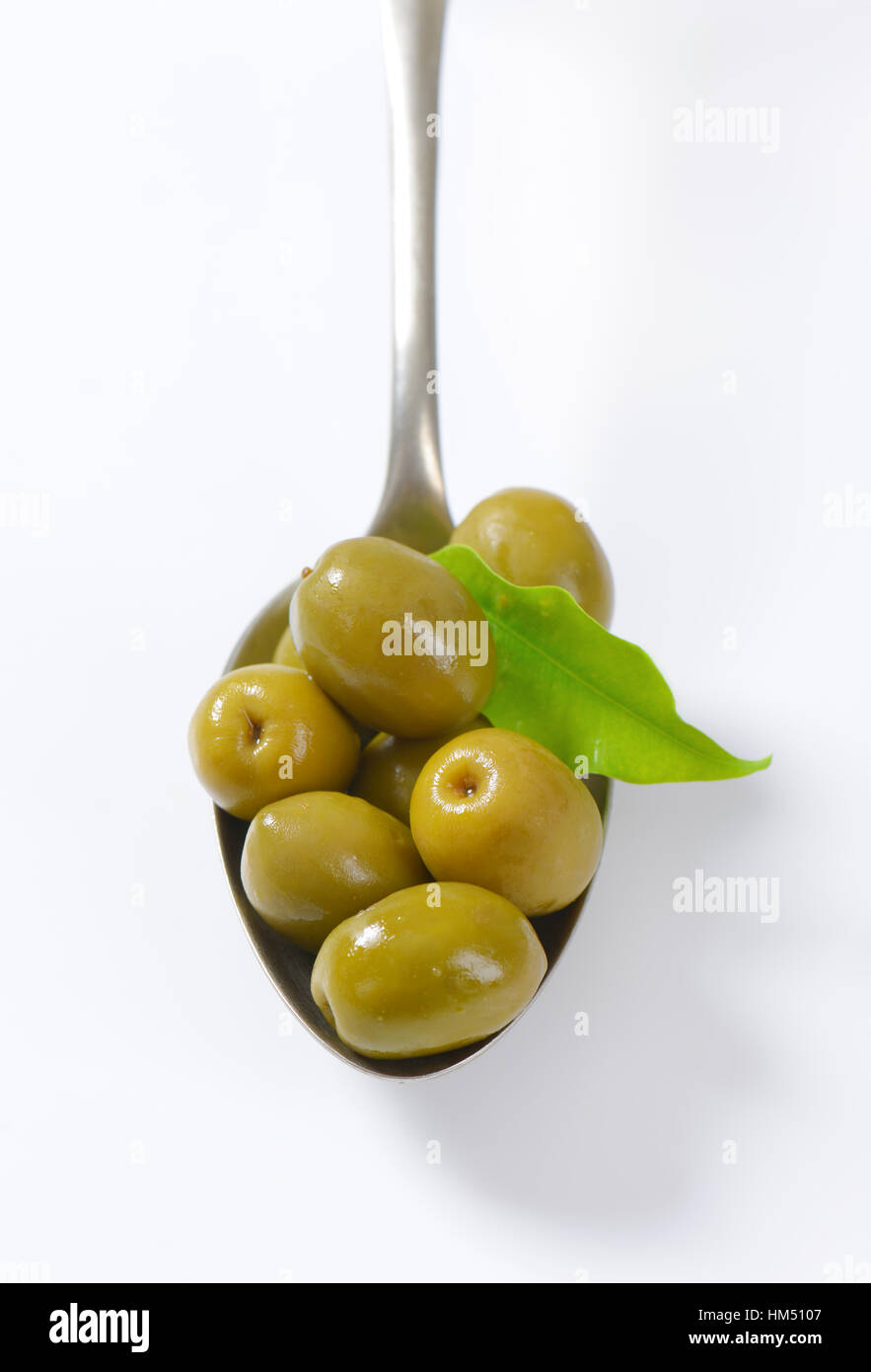 spoon of green olives on white background Stock Photo - Alamy