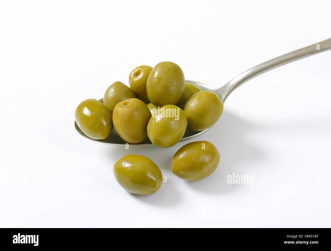 spoon of green olives on white background Stock Photo - Alamy
