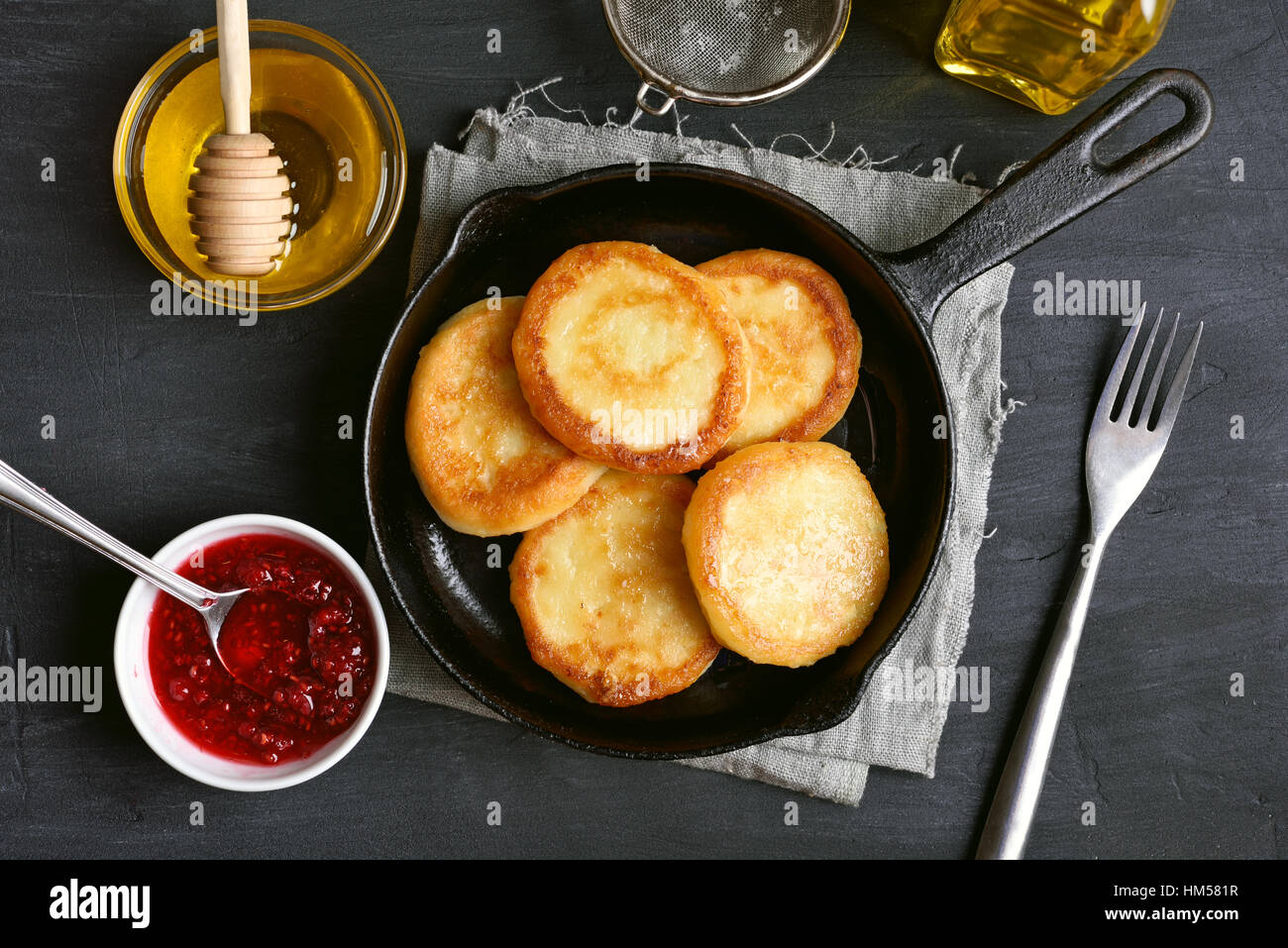 Cheesecakes, curd cheese pancakes in cast iron frying pan, top view