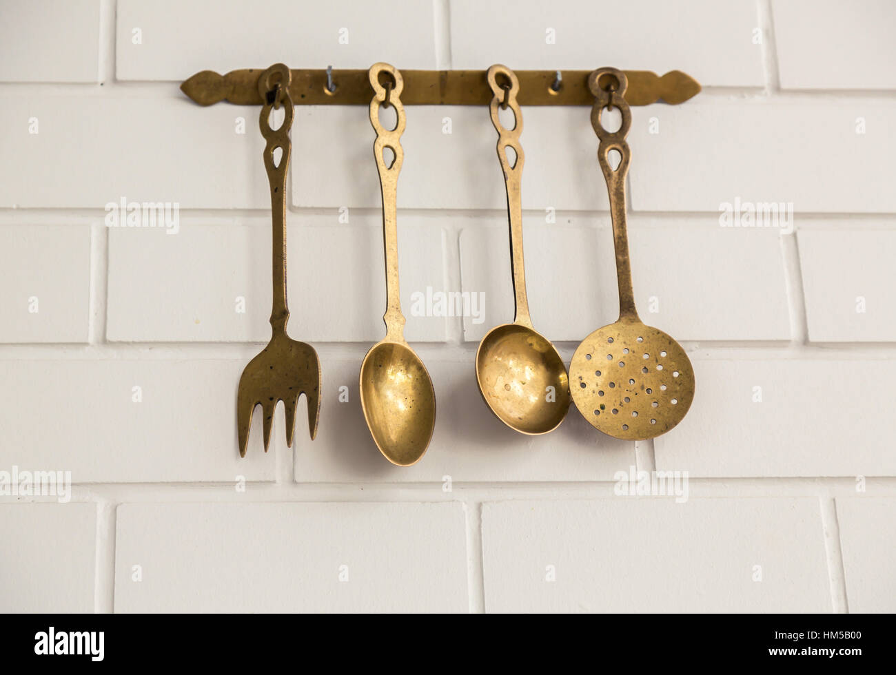 Vintage kitchen spoon and fork hanging on wall ( Filtered image