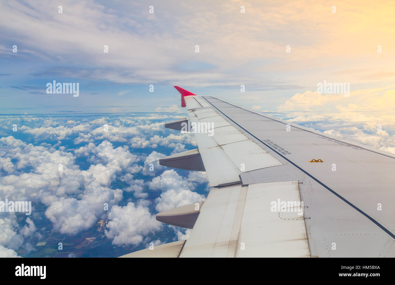 Wing of an airplane flying above the clouds Stock Photo - Alamy