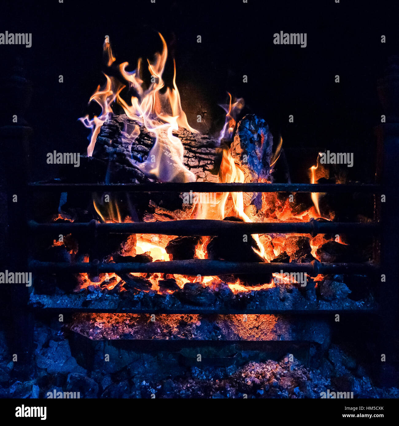 A close up fireplace showing logs and coal burning Stock Photo