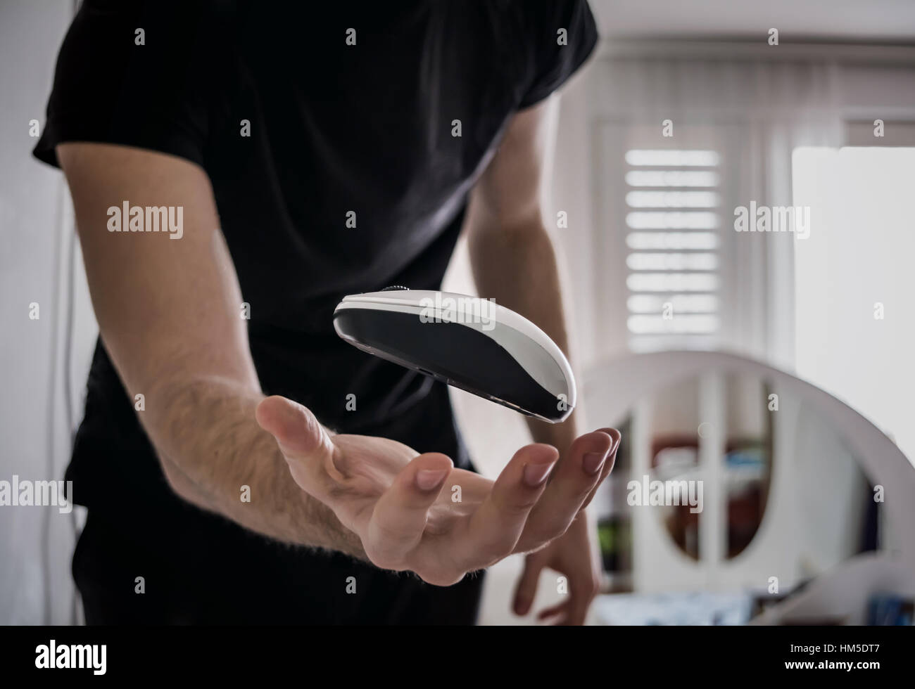 Flying computer mouse (Guy trowing computer mouse in the air Stock