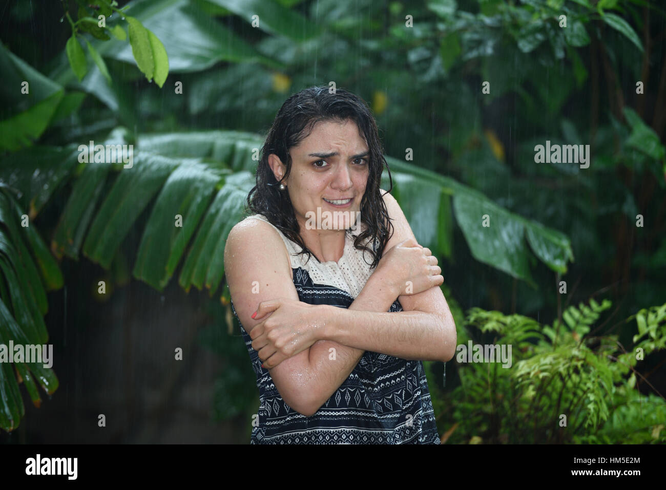 woman feel cold in pouring rain without umbrella Stock Photo