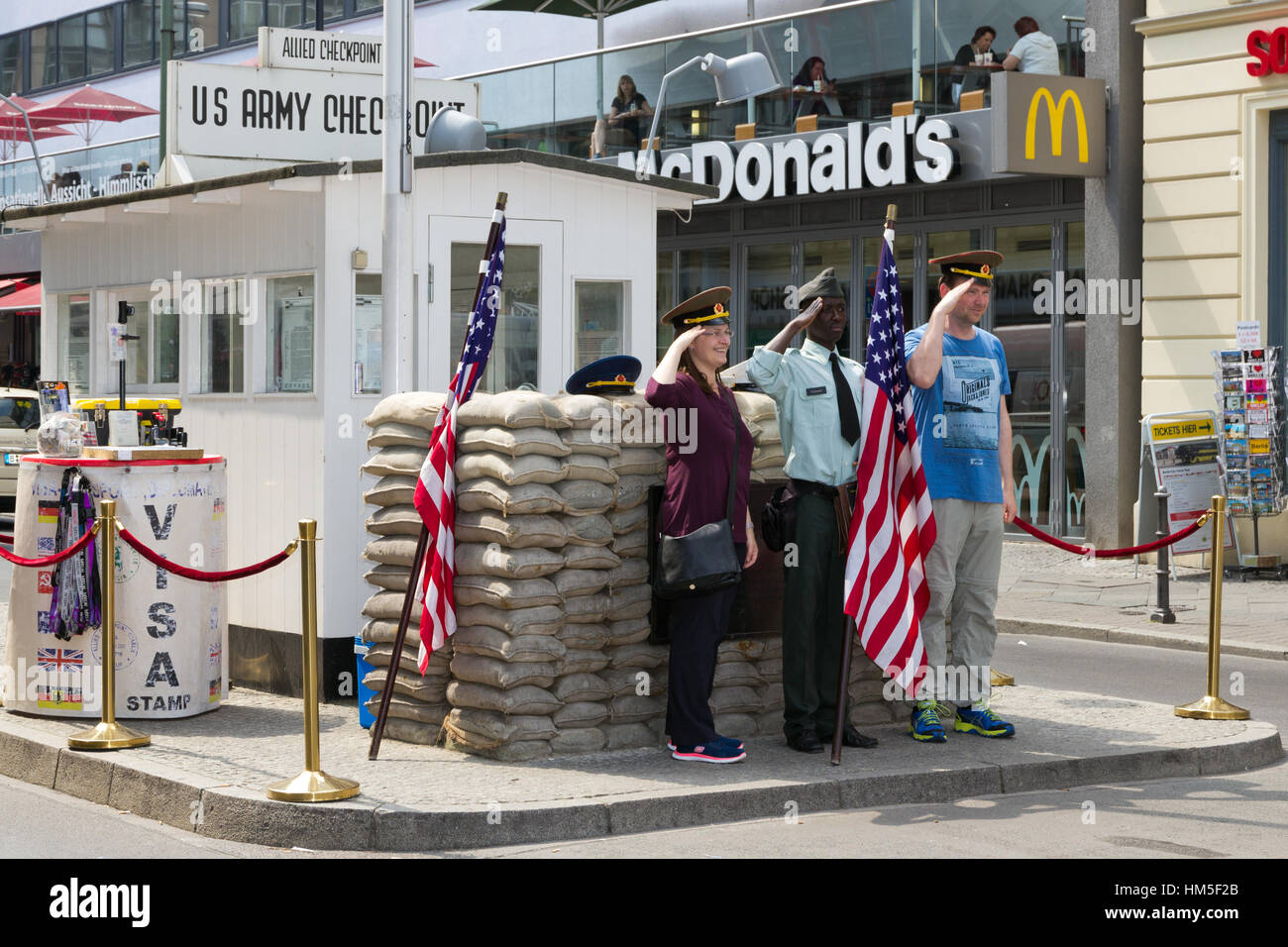BERLIN, GERMANY - MAY 23: Tourists posing at the former Allied checkpoint 'Charlie' on May 23, 2014. Nowadays this site is a tourist attraction. Stock Photo