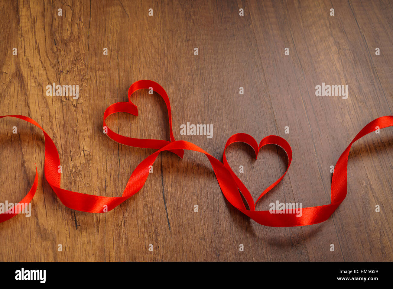 Red ribbon hearts on wood background For Valentines day Stock Photo - Alamy