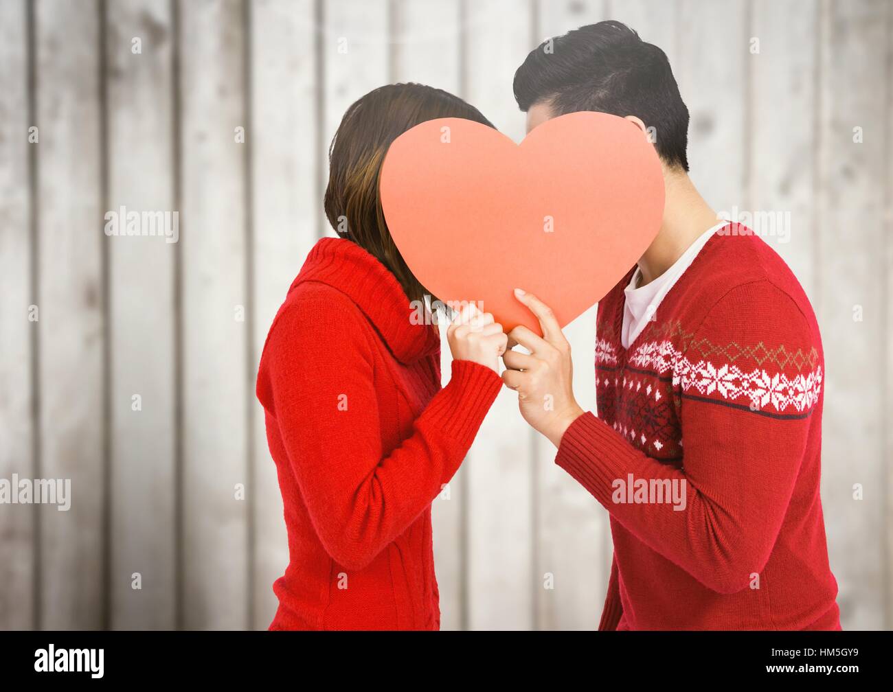 Couple kissing behind heart Stock Photo - Alamy