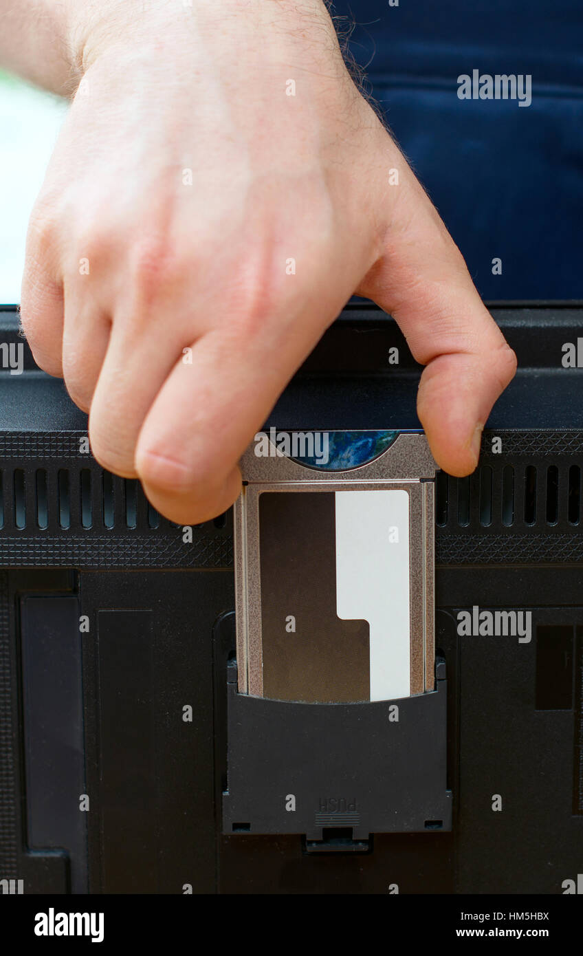 Man installing conditional access module card to TV Stock Photo - Alamy