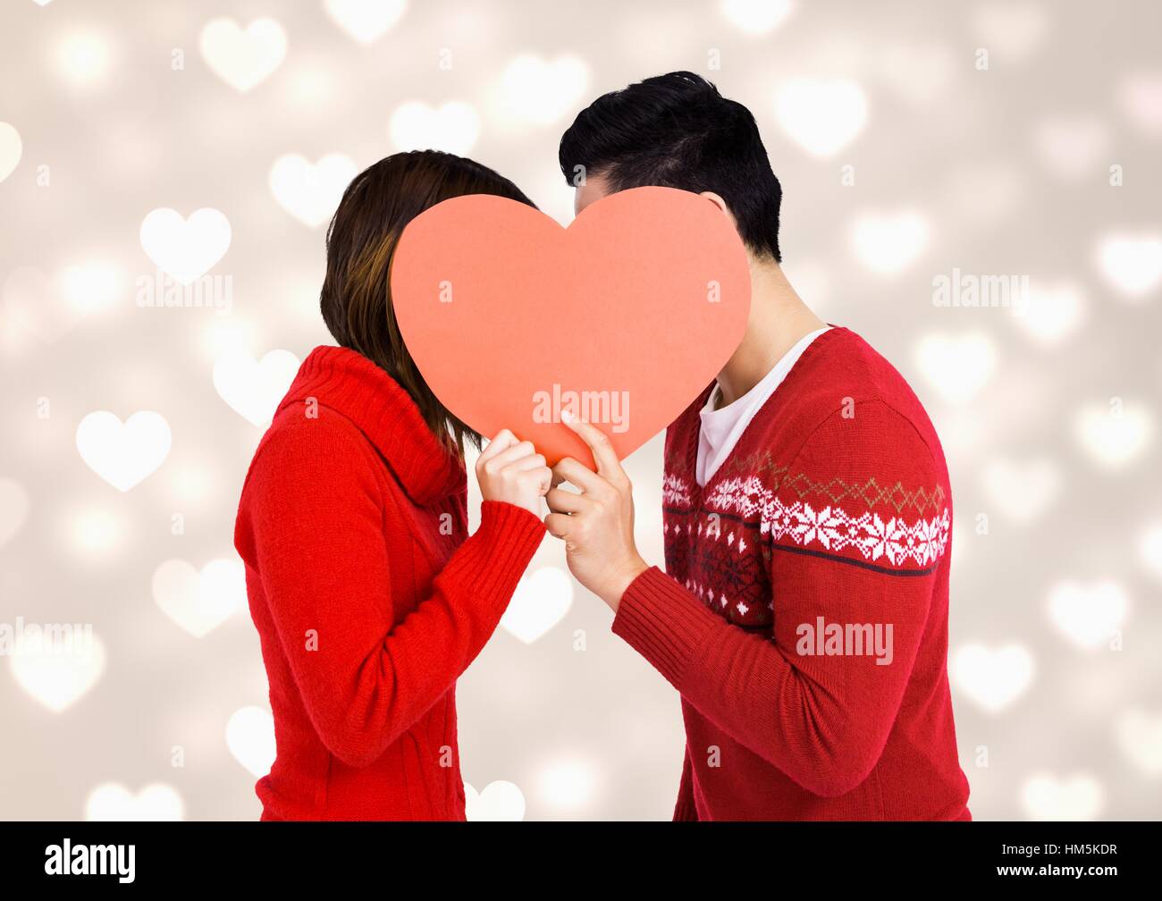 Romantic couple hiding their face behind red heart Stock Photo - Alamy