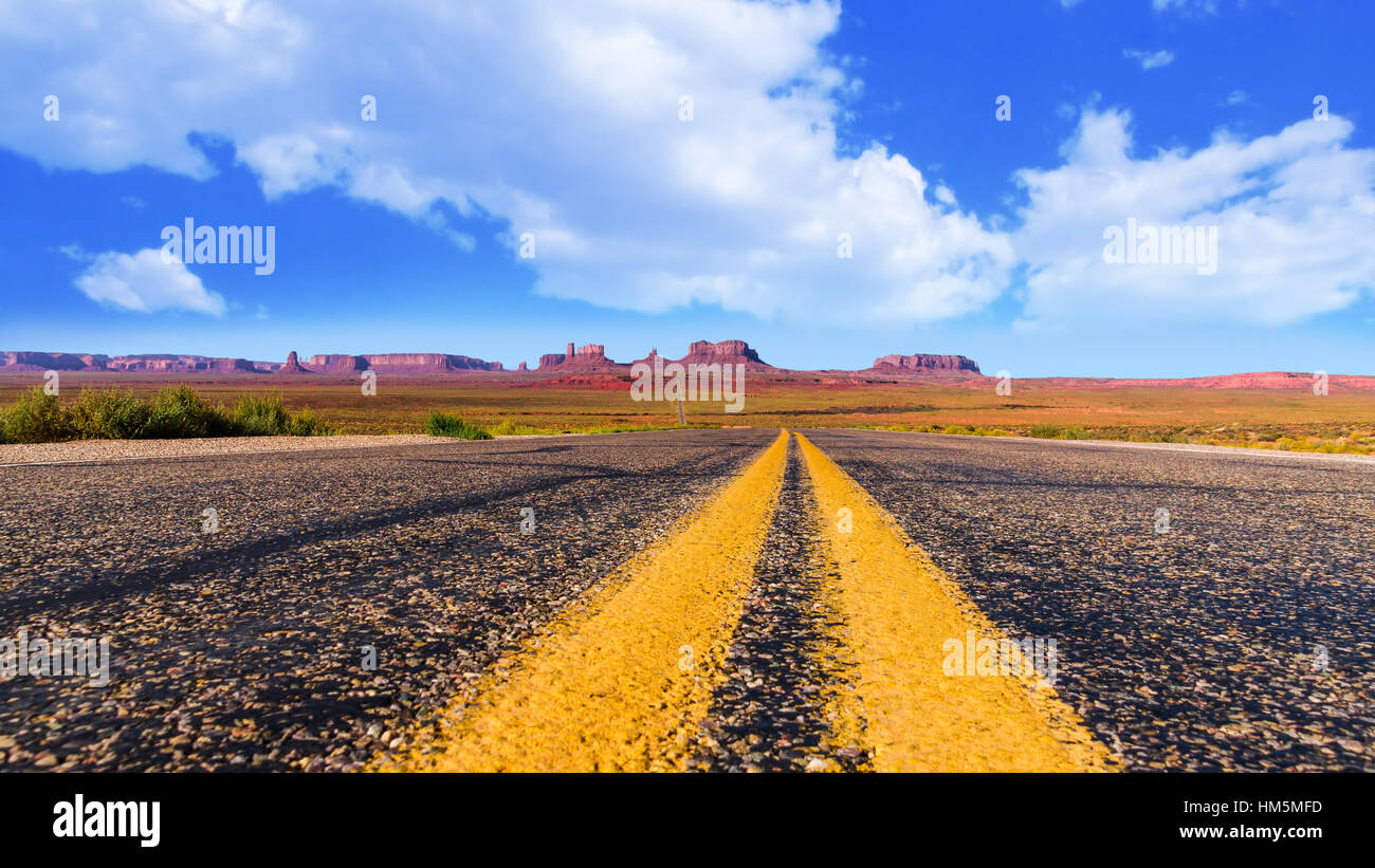 Panoramic view on monument valley in Arizona and Utah from the middle of the road at forrest gump point with typical yellow us highway road marking an Stock Photo