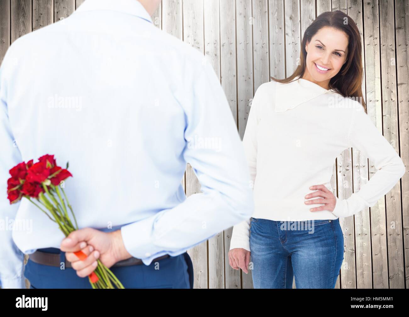 Man hiding bunch of roses from woman Stock Photo - Alamy