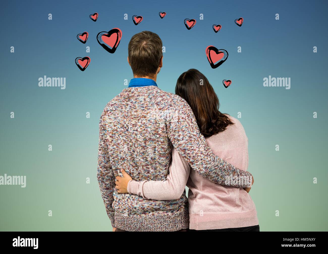 Rear view of couple standing with arms around Stock Photo