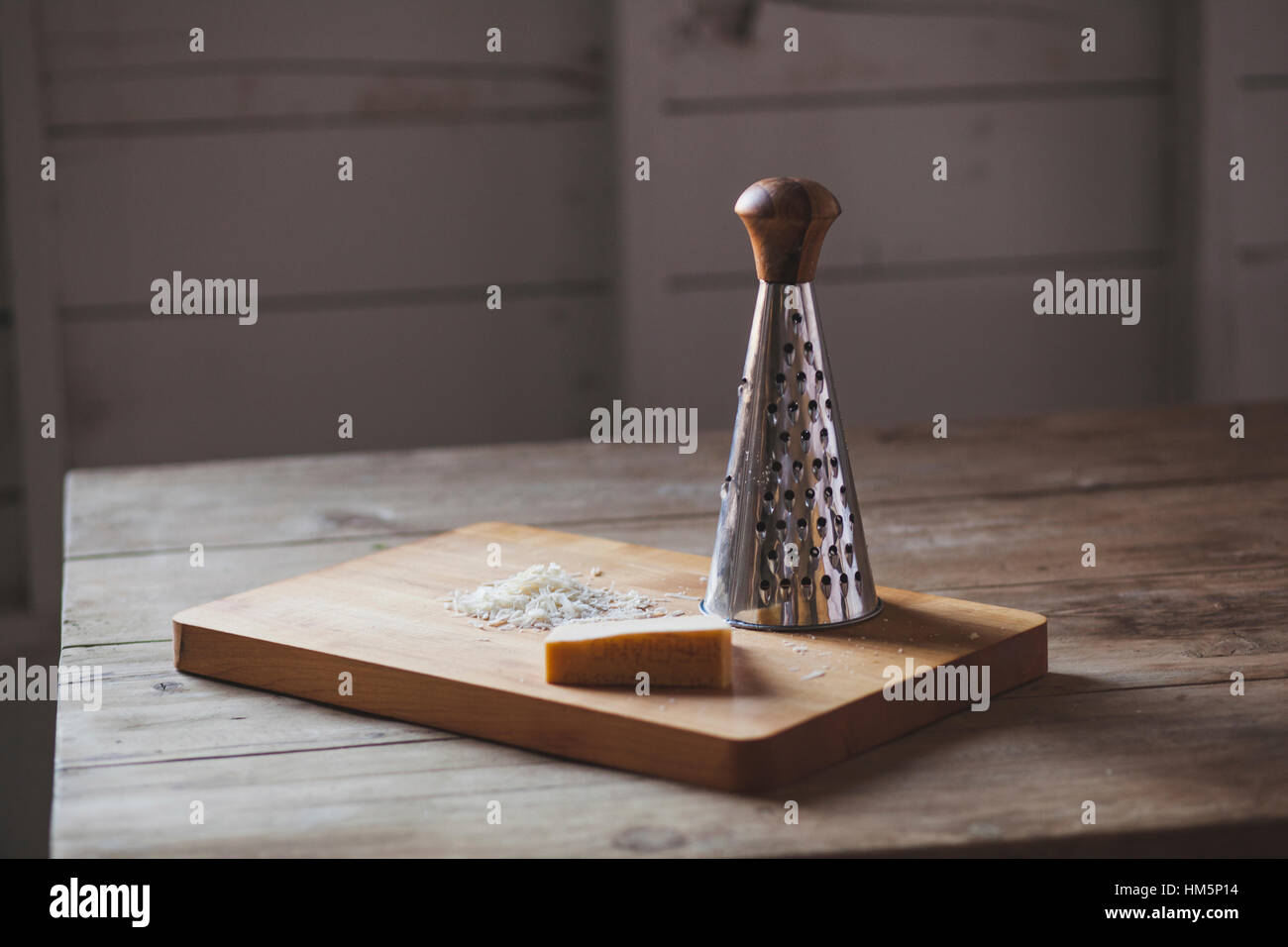 Italian hard cheese with grater on wooden background Stock Photo - Alamy