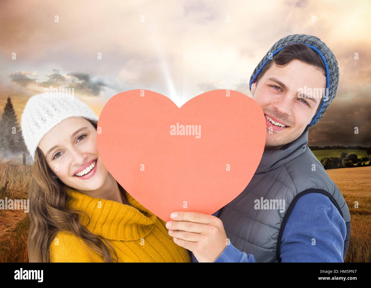 Romantic couple holding heart against sky background Stock Photo - Alamy