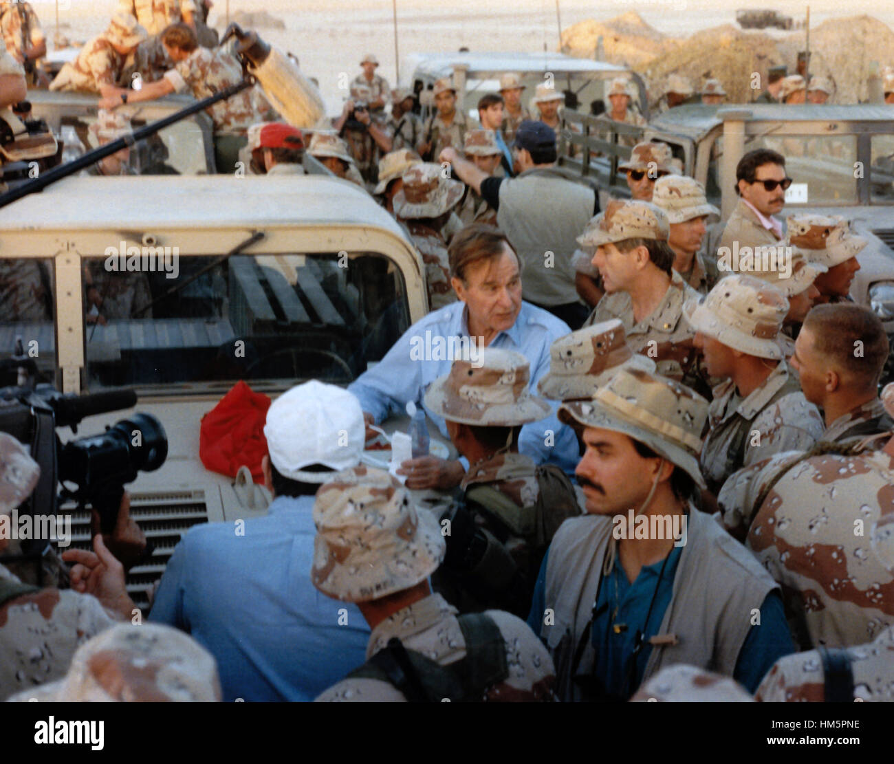 United States President George H.W. Bush shares a Thanksgiving holiday meal with US military personnel in Saudi Arabia on November 22, 1990. Mandatory Stock Photo