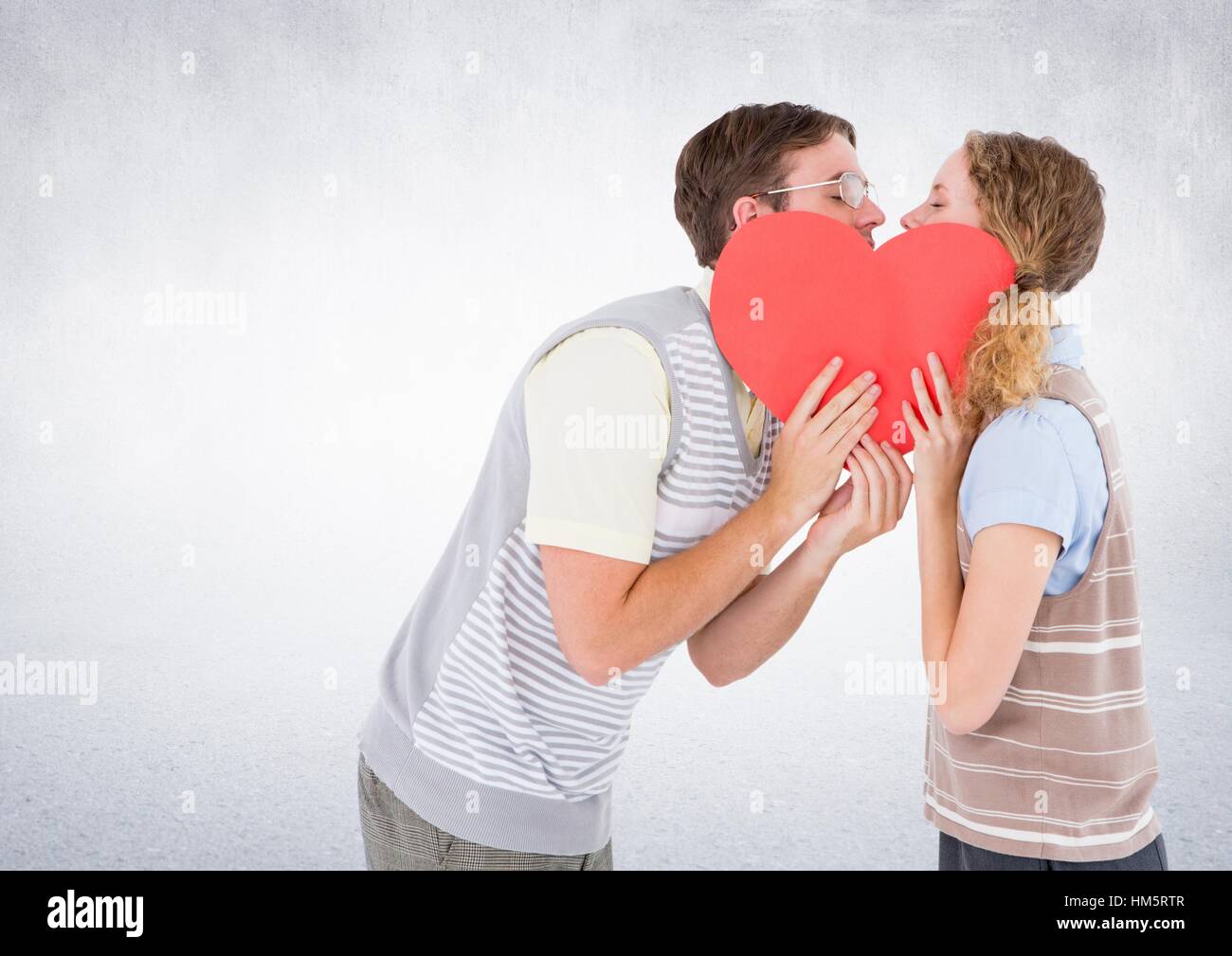 Romantic couple kissing behind heart Stock Photo - Alamy