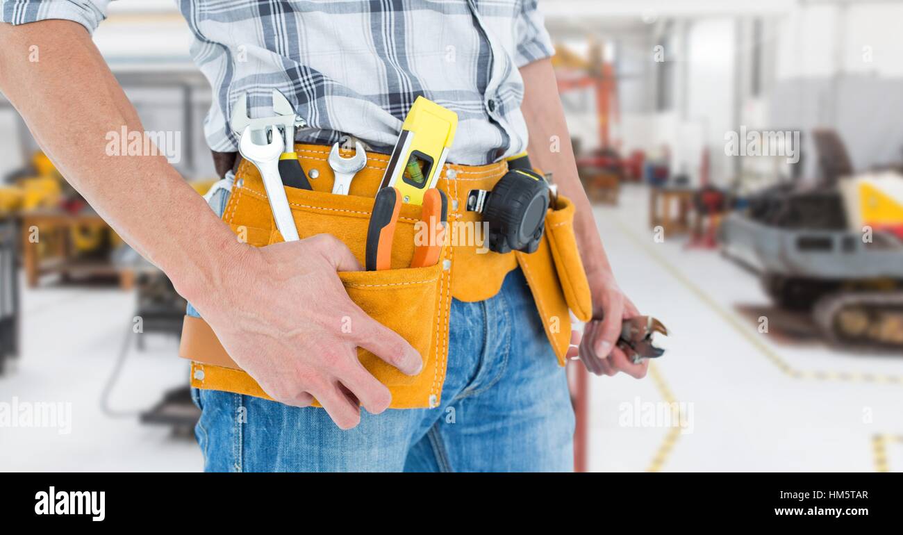 Handyman with tool belt at workshop Stock Photo - Alamy