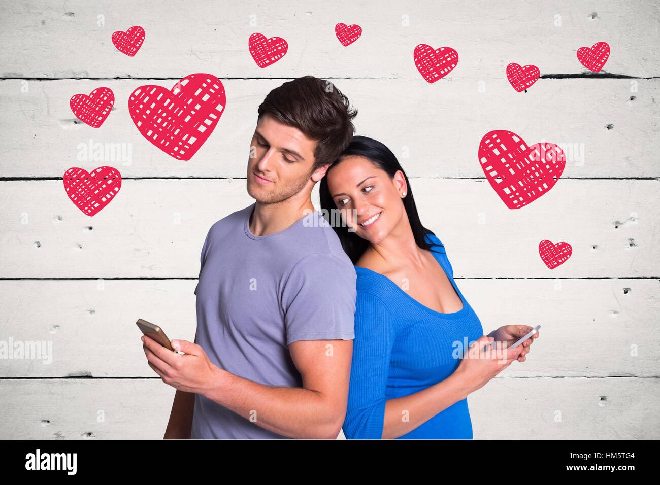 Romantic couple texting message against red hearts on wooden panel Stock Photo