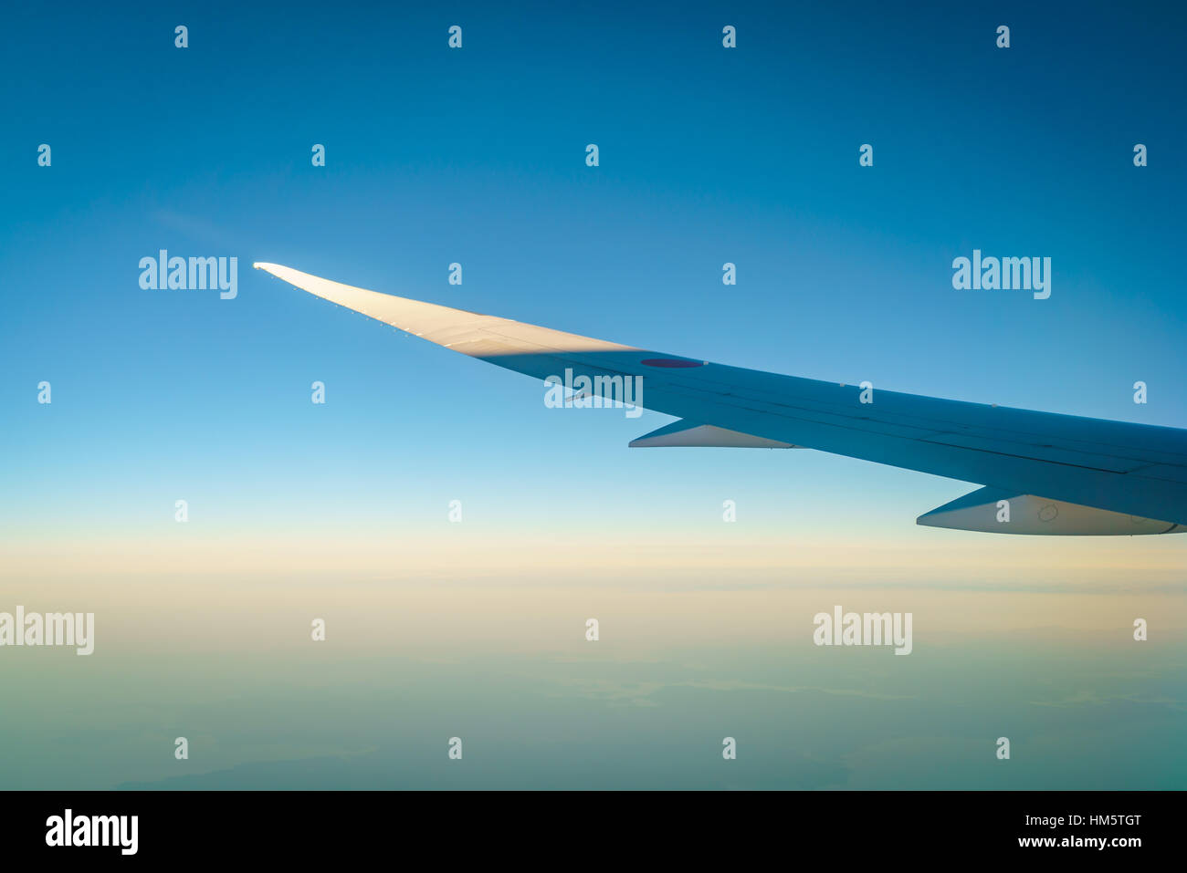 Wing of an airplane flying above the clouds Stock Photo - Alamy