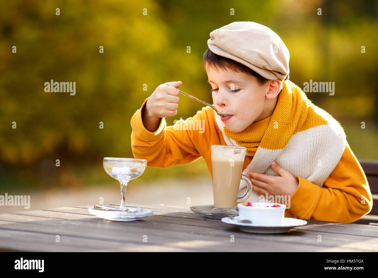 3 year old boy drinking mug of hot chocolate in a cafe Stock Photo - Alamy