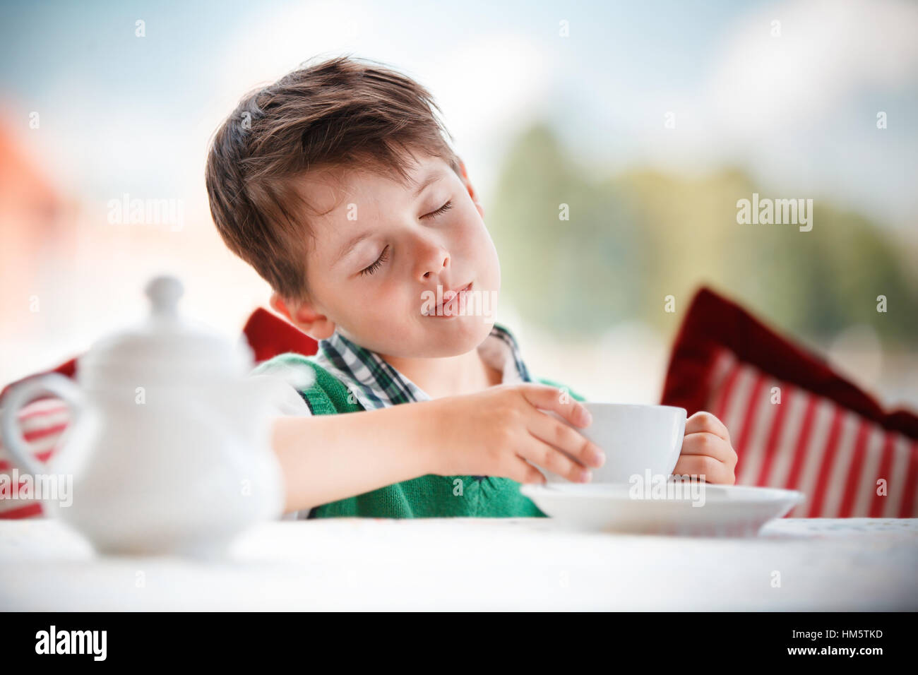 Cute little boy drinking tea in cafe Stock Photo Alamy
