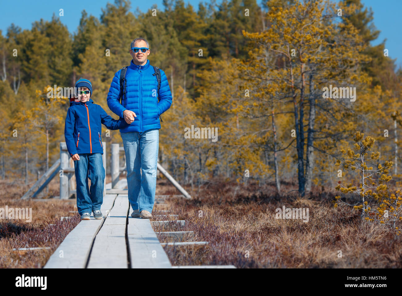 Cute little boy with father walking on trail in swamp, Kemeri national park, Latvia Stock Photo
